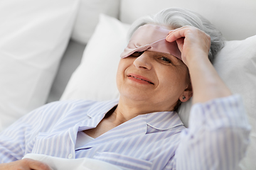 Image showing senior woman with eye sleeping mask in bed at home