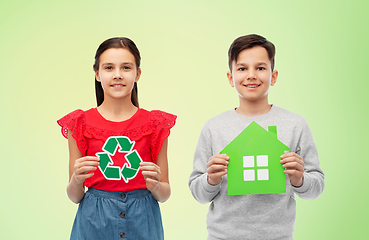 Image showing smiling little girl and boy holding green houses