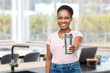 Image showing woman with thermo cup or tumbler at home