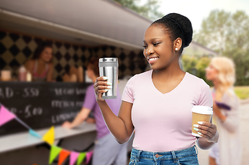 Image showing woman with coffee cup and tumbler over food truck