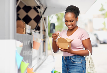 Image showing happy woman eating wok over food truck