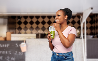 Image showing happy african american woman drinking green juice