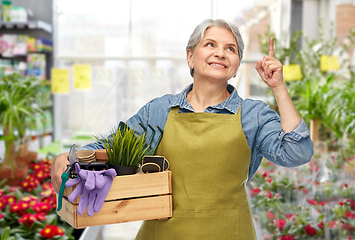 Image showing smiling senior woman with garden tools in box