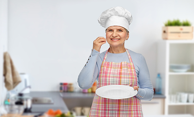 Image showing smiling senior woman or chef holding empty plate