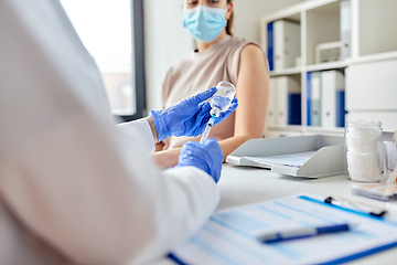 Image showing female doctor with syringe vaccinating patient