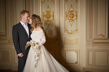 Image showing Young beautiful just married couple sharing romantic moments with each other. Fashion couple in luxury interior in the Baroque style