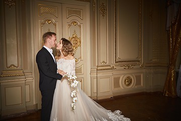 Image showing Young beautiful just married couple sharing romantic moments with each other. Fashion couple in luxury interior in the Baroque style