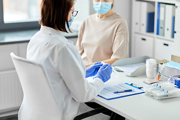 Image showing female doctor with syringe and patient at hospital