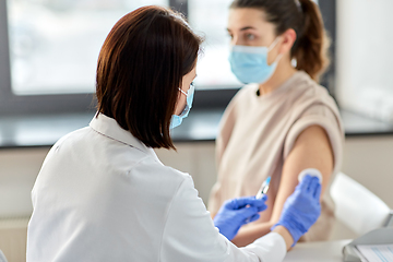 Image showing female doctor with syringe vaccinating patient