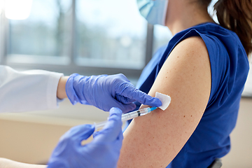 Image showing doctor with syringe vaccinating medical worker