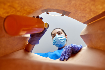 Image showing woman in gloves and mask with food in paper bag