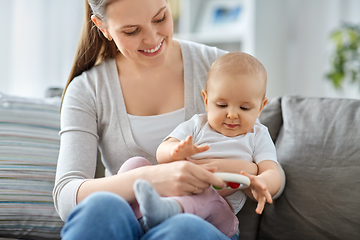 Image showing mother and little baby playing with rattle at home