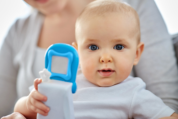 Image showing mother with baby playing with toy phone at home