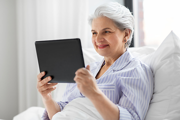 Image showing senior woman with tablet pc in bed at home bedroom