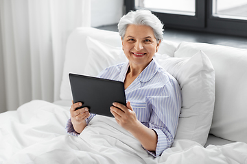 Image showing senior woman with tablet pc in bed at home bedroom