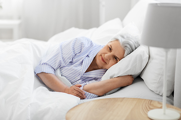 Image showing senior woman lying in bed at home bedroom