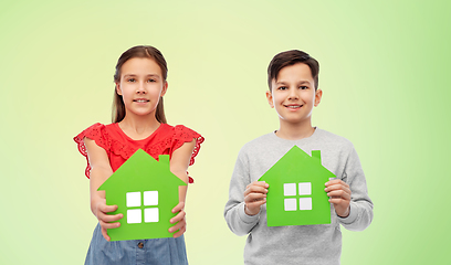 Image showing smiling little girl and boy holding green houses