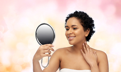 Image showing smiling african american woman looking to mirror