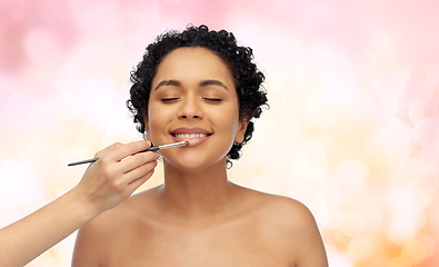 Image showing happy woman and hand of make up artist with brush