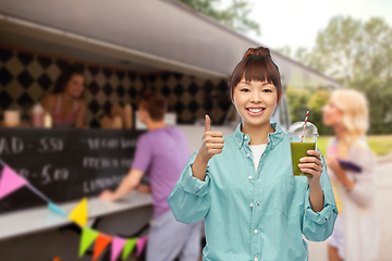 Image showing happy asian woman with juice over food truck