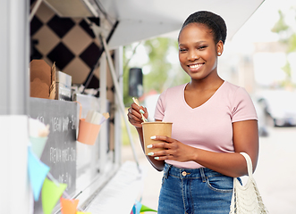 Image showing happy woman eating wok over food truck