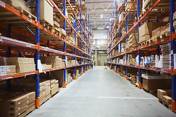 Image showing Huge distribution warehouse with high shelves and loaders.