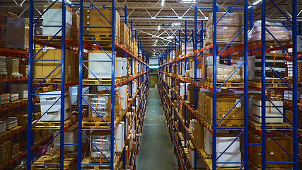 Image showing Huge distribution warehouse with high shelves and loaders.