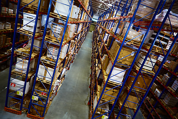 Image showing Huge distribution warehouse with high shelves and loaders.