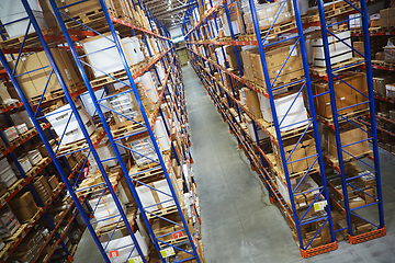 Image showing Huge distribution warehouse with high shelves and loaders.