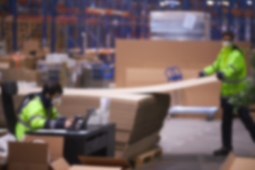 Image showing Blur warehouse background. Warehouse worker taking package in the shelf in a large warehouse in a large warehouse