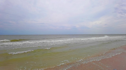 Image showing Big tide waves with foam and splashes are crushing beach in slow motion.