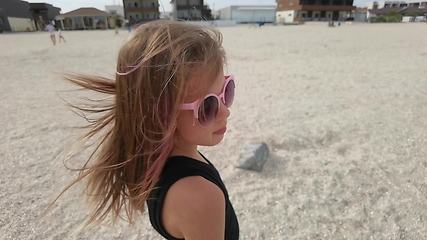 Image showing close up portrait girl looking serious contemplative kid on sunny seaside beach real people series