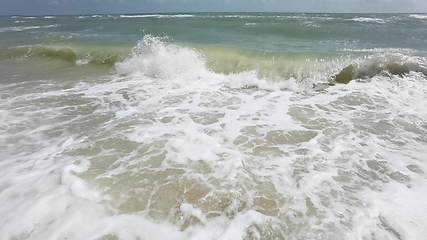 Image showing Powerful ocean waves crashing on a coast. Extreme stormy ocean waves splashing on a Beach