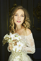 Image showing Beautiful bride portrait with wedding bouquet in a luxurious dress in eco-style