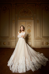 Image showing Fashion portrait of beautiful woman in long elegant white dress. Girl with elegant hairstyle. Bridal fashion model in luxury interior in the Baroque style