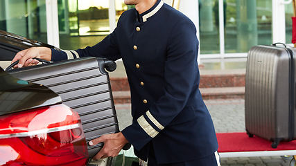 Image showing Bellboy taking baggage of guest from thee car to his room