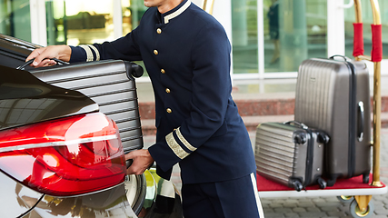 Image showing Bellboy taking baggage of guest from thee car to his room