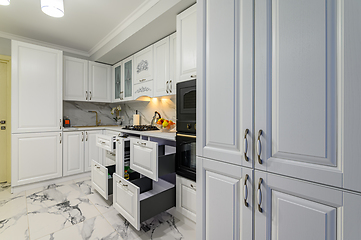 Image showing Open drawers with kitchenware at modern white kitchen