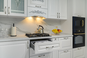 Image showing Open drawers with kitchenware at modern white kitchen