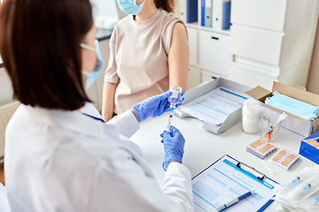 Image showing female doctor with syringe vaccinating patient