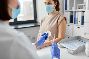 Image showing female doctor with syringe vaccinating patient