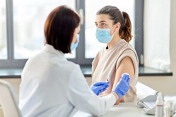 Image showing female doctor with syringe vaccinating patient