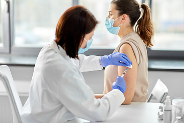 Image showing female doctor with syringe vaccinating patient