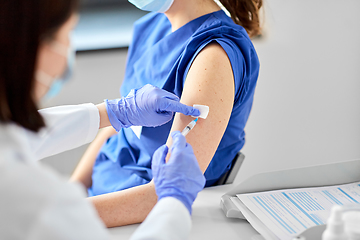 Image showing doctor with syringe vaccinating medical worker