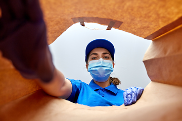 Image showing delivery girl in gloves and mask with food in bag