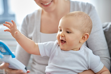 Image showing mother with baby playing with toy phone at home