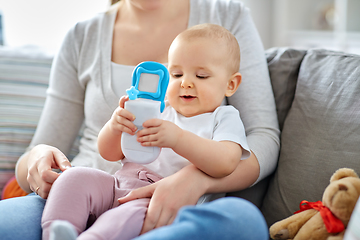 Image showing mother with baby playing with toy phone at home