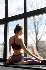 Image showing woman doing yoga exercise on window sill at studio