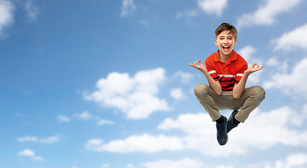 Image showing happy young boy flying in yoga pose over sky