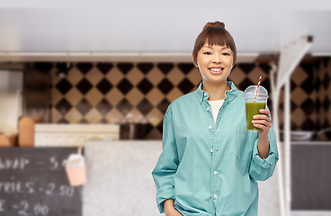 Image showing happy asian woman with juice over food truck